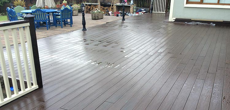 teranna ever shield walnut composite decking that looks and feels like natural wood installed on the terrace in the background