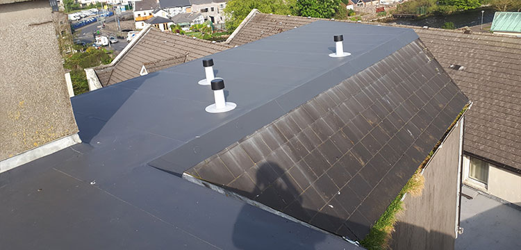 Roof recovery with Alkorplan 1.5mm single ply PVC membrane and roof vents with cowls and pvc vertical rain water outlets installed in galway apartment block